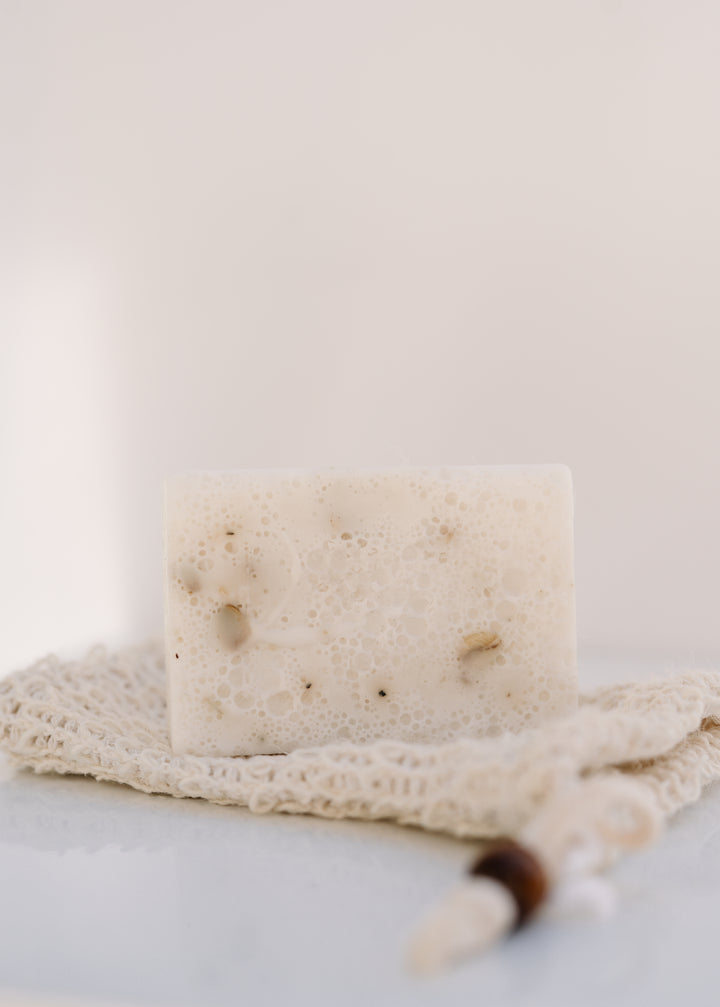 Bar of soap on a textured surface with a white background.