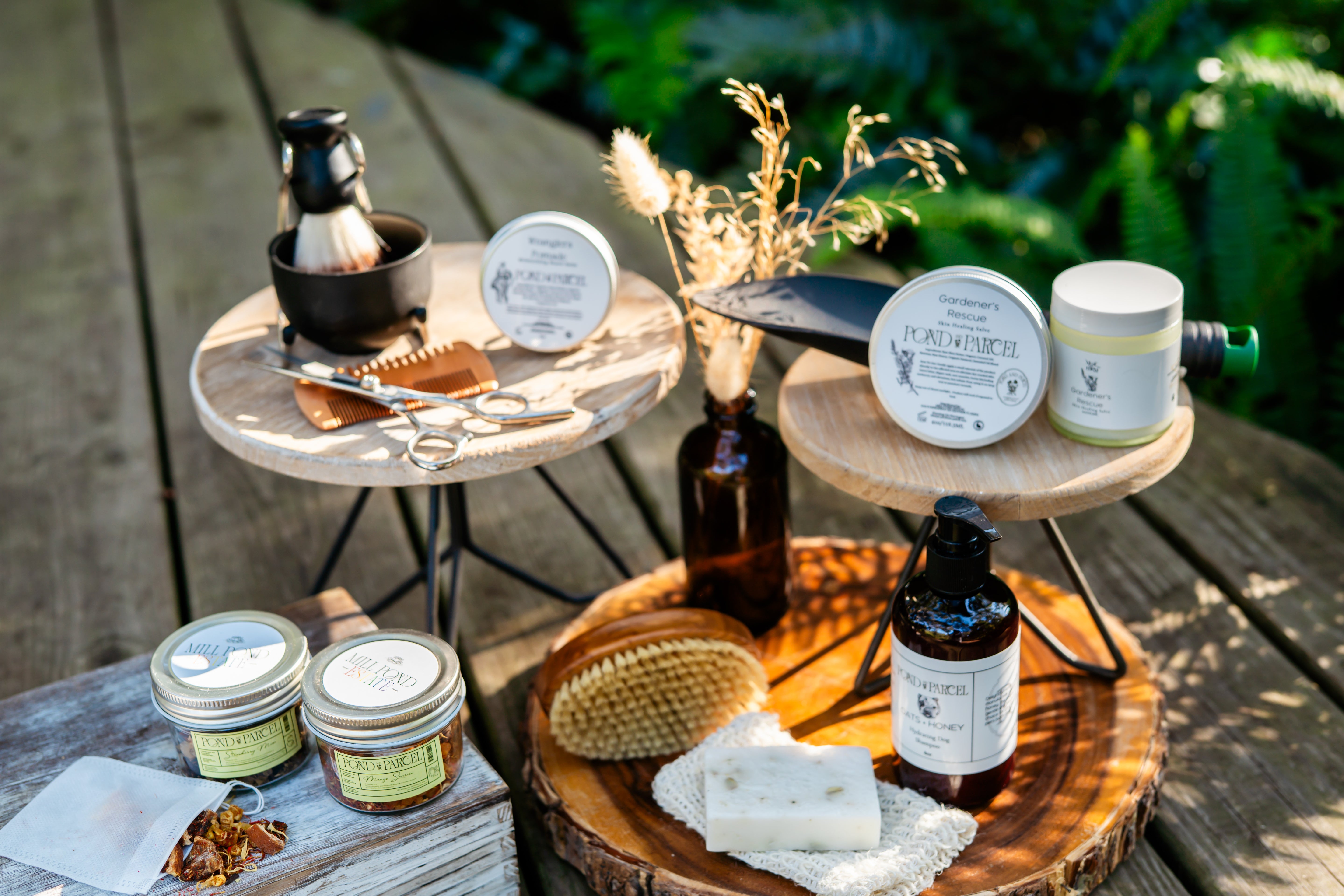 Collection of natural beauty products on wooden and stone surfaces outdoors.