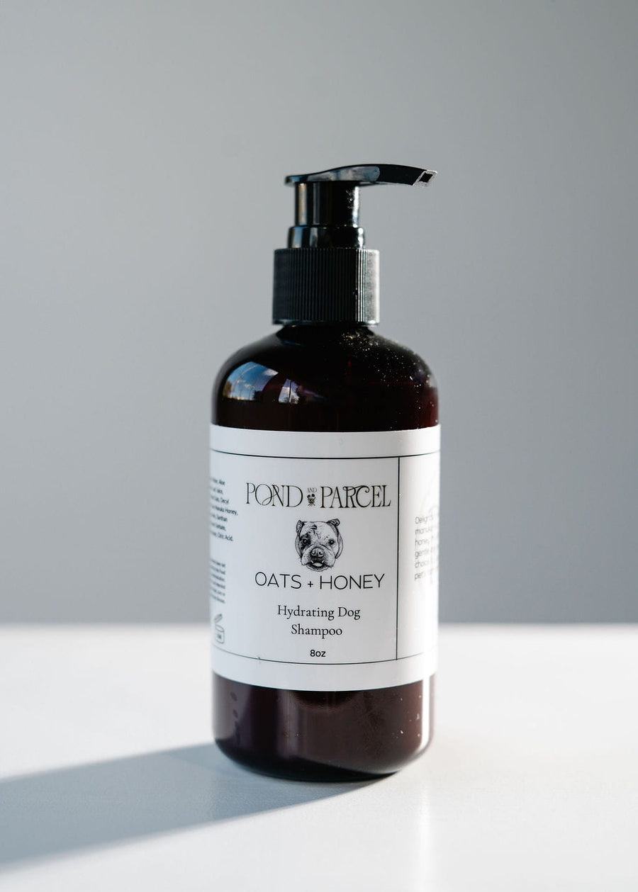 Bottle of Fond & Parcel Oats + Honey Hydrating Dog Shampoo on a gray background