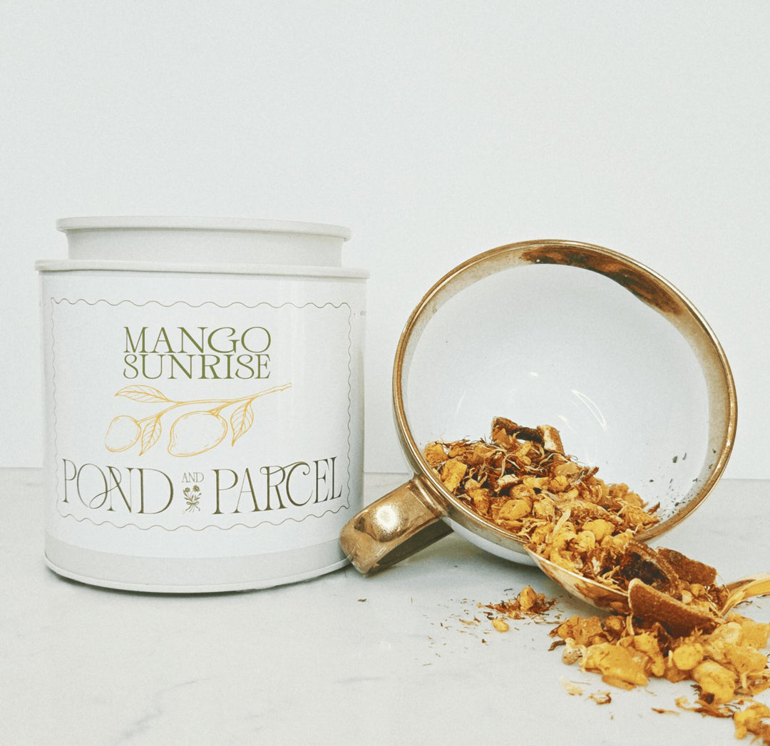 White container labeled 'Mango Sunrise' from 'Pond & Parcel' with a scoop of tea leaves.